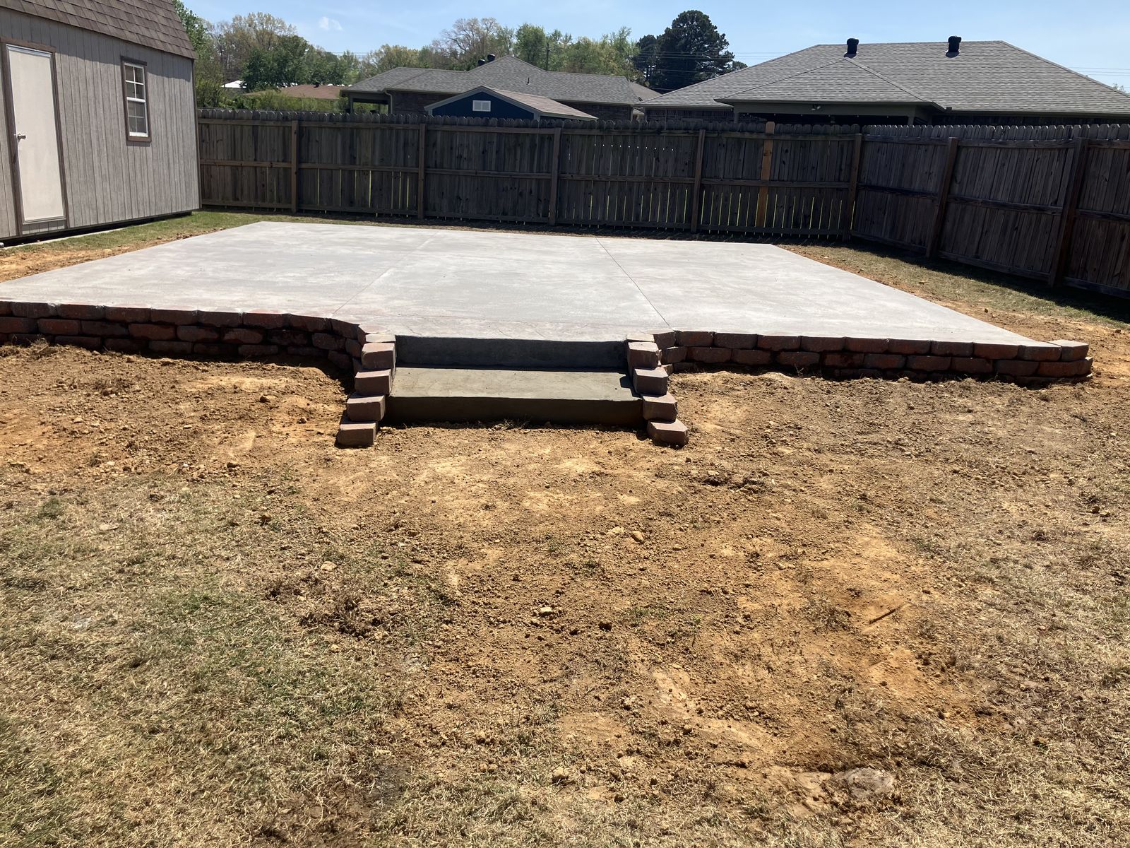 Concrete slab with a block retaining wall and steps in Arkansas